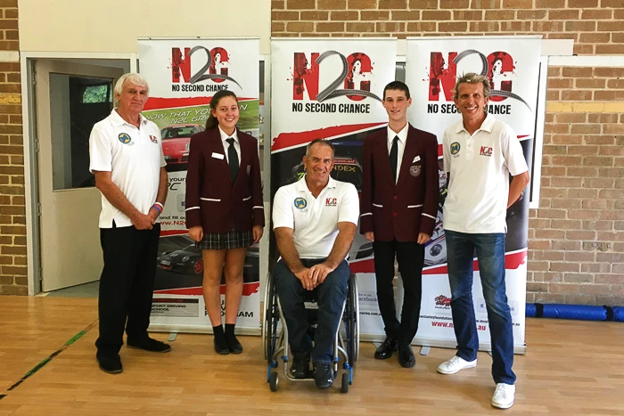 Two Aberfoyle Park High School students with Paul Stanley, Matt Speakman and Warren Luff in front of N2C banners